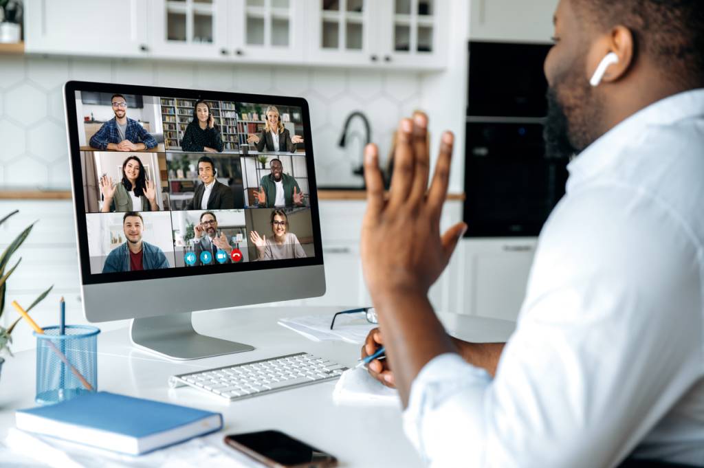 Photo of man waving during a virtual work meeting 