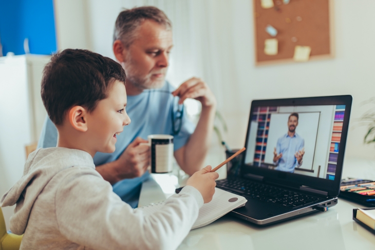 Image of father and son in fron of laptop screen for online tutoring services