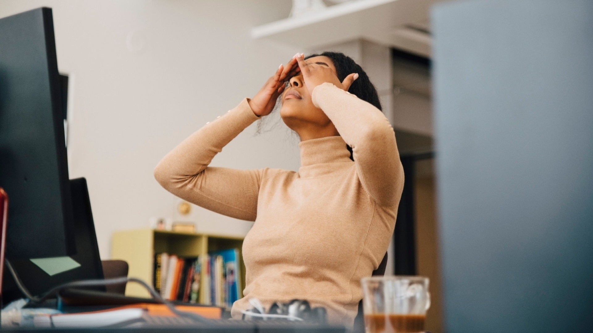 Image of woman frustrated from work burnout in front of her desktop